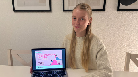 Leoni Schramm zeigt Plakat zur Veranstaltung \